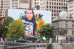 Photo of a mural of a Narragansett woman holding a photo.