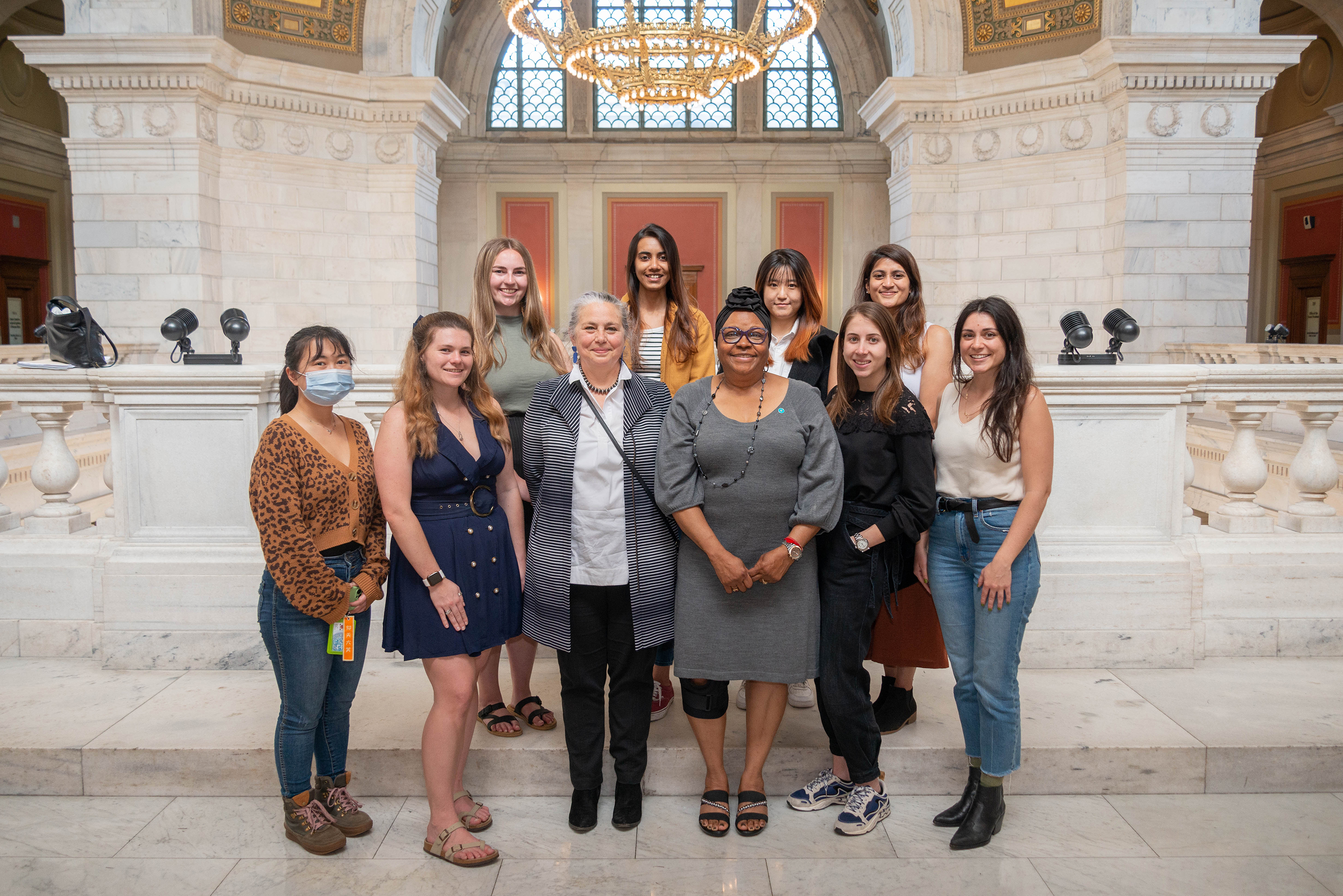 students pose on the State House steps with Representative Anastasia Williams 