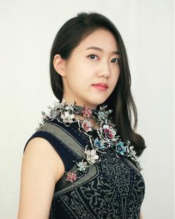 Woman wearing a jeweled floral chest harness created by a student
