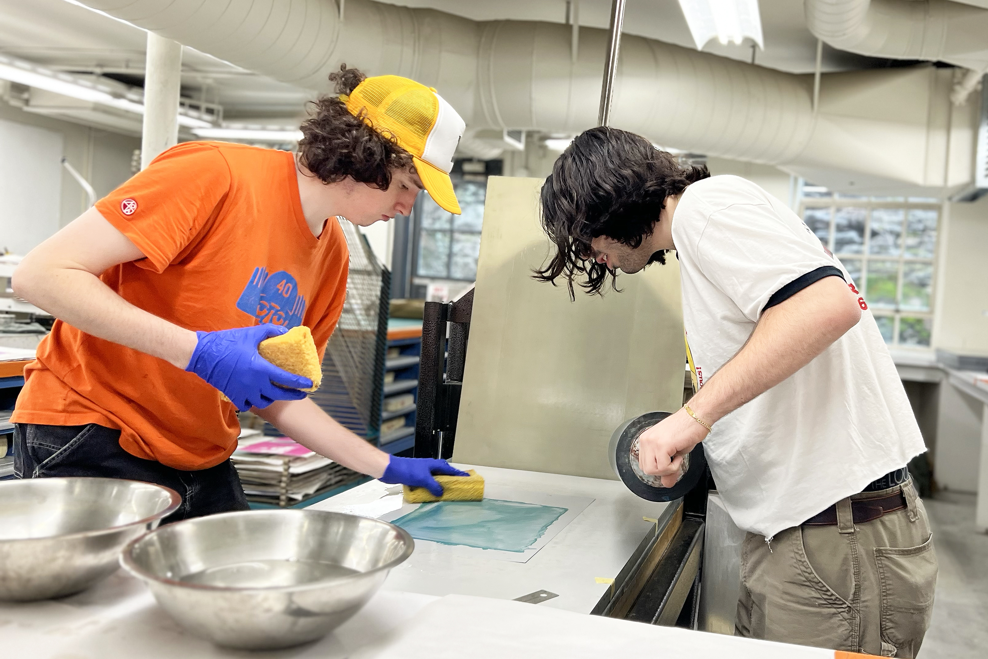two male students work together in the printmaking studio