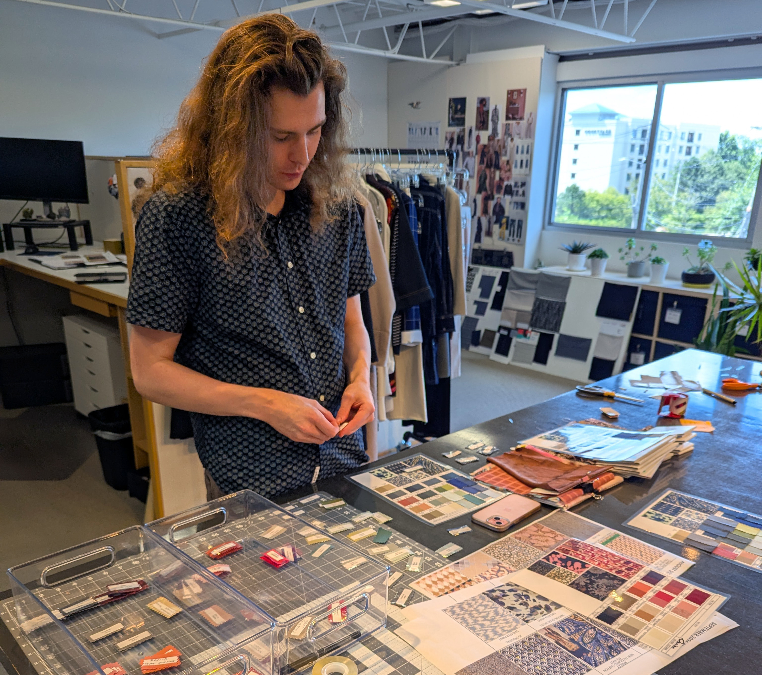 Nick Merlo with swatches and patterns laid out on a worktable