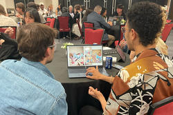 A student and a RISD alum face a laptop for a portfolio review