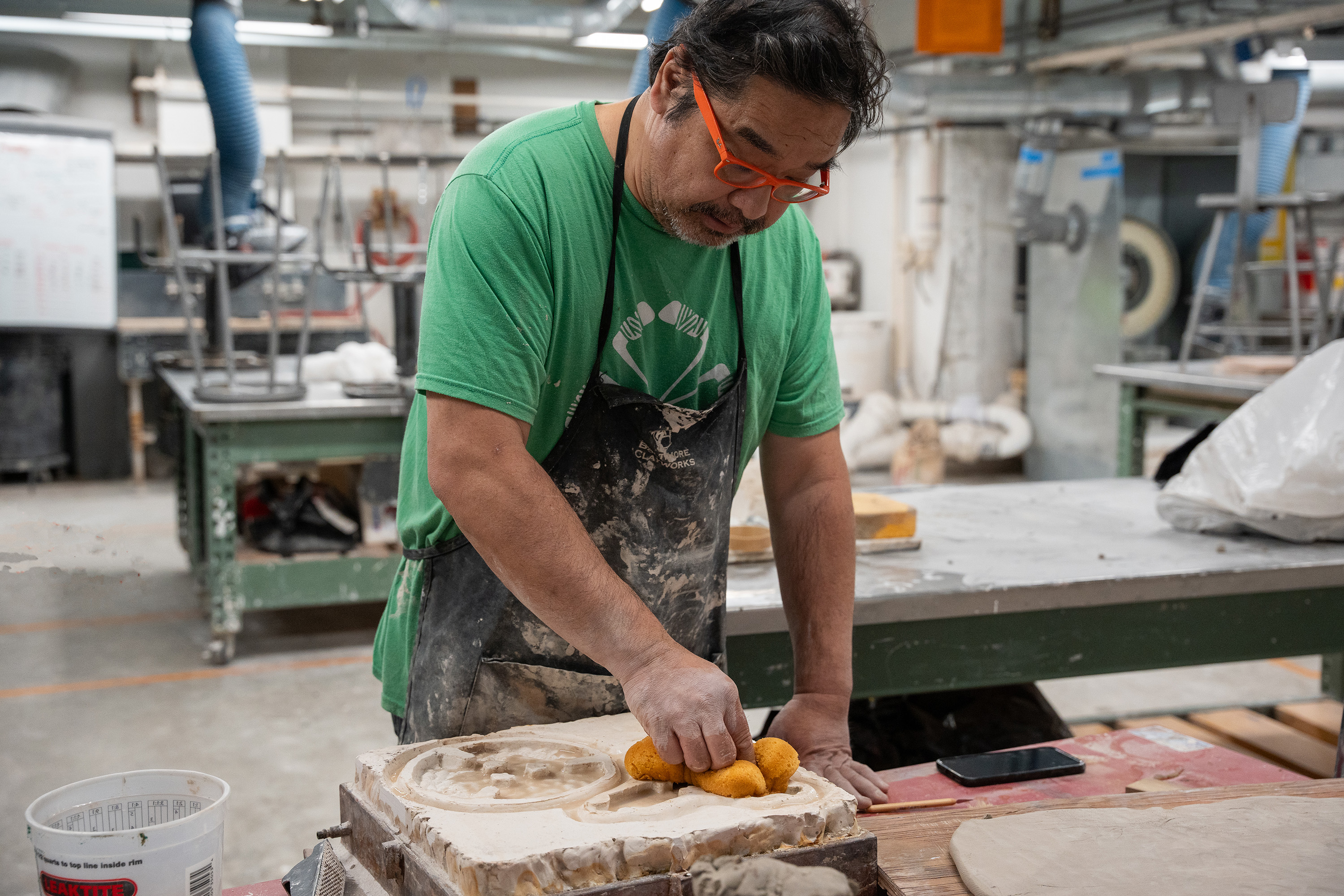 Associate Professor Shoji Satake cleans the dye with an orange sponge