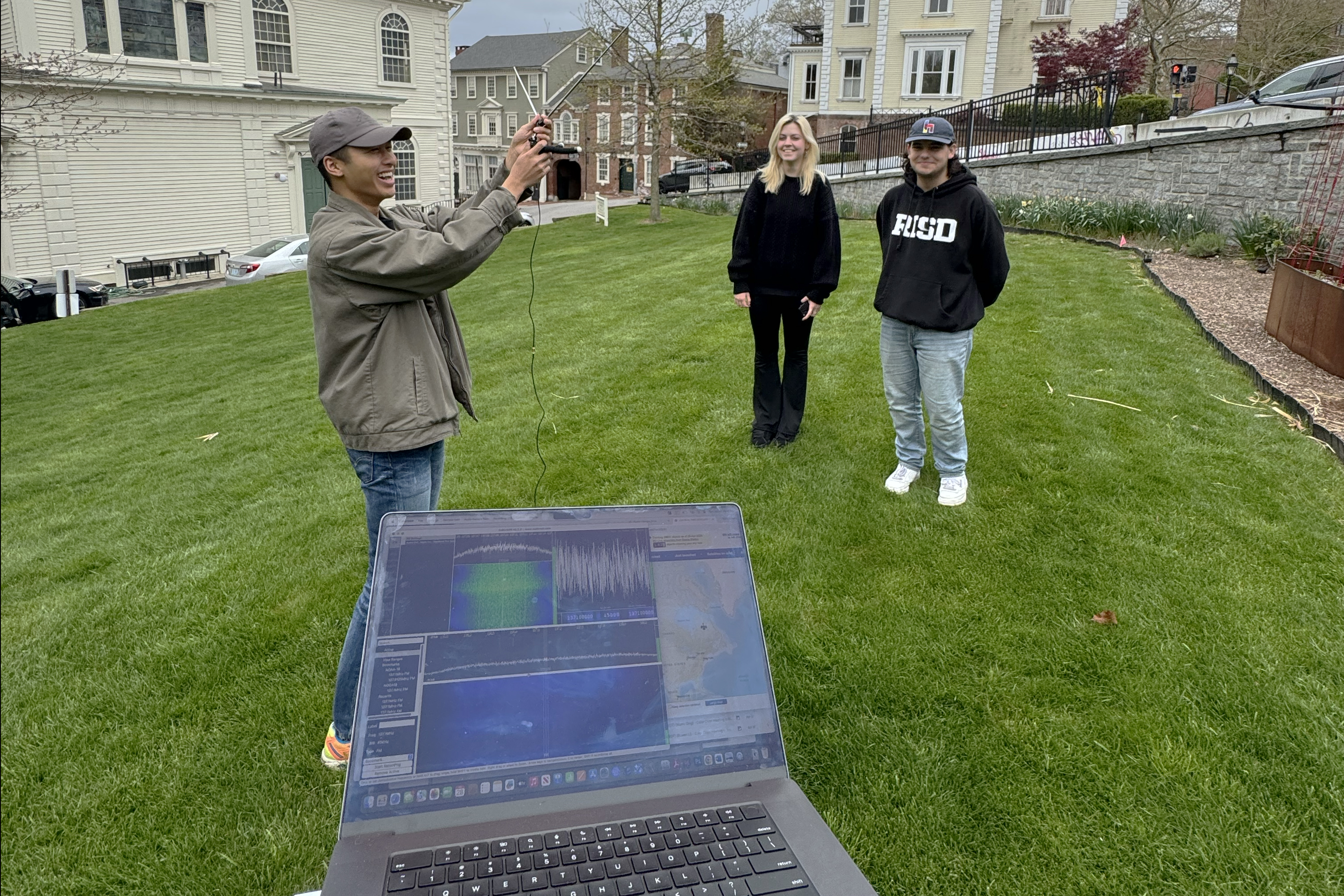 students setting up a mobile satellite station on the lawn in front of the First Baptist Church