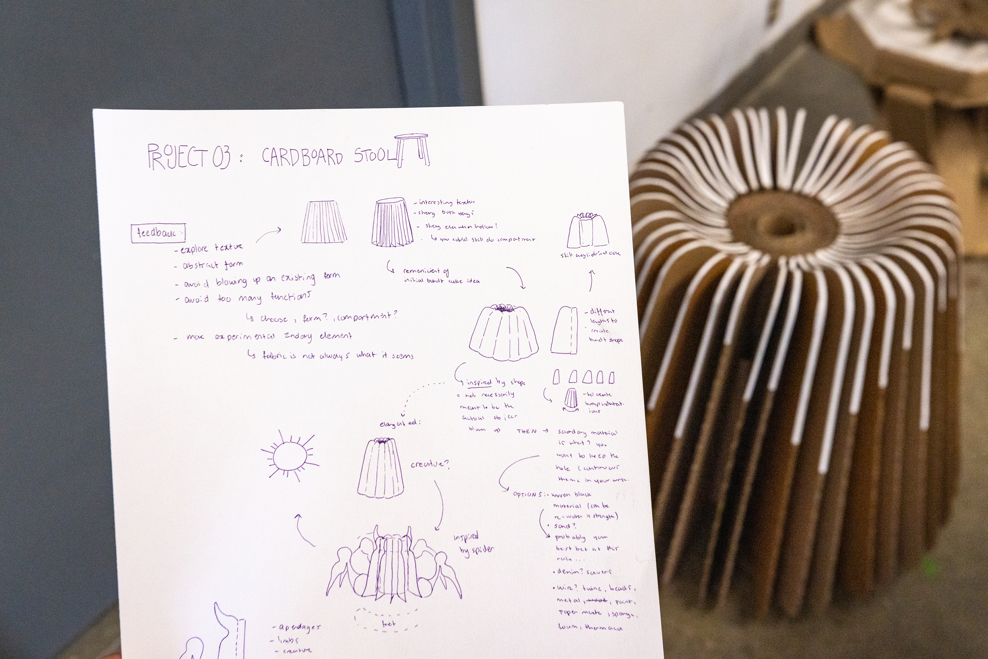 image of a student sketchbook with the finished stool in the background