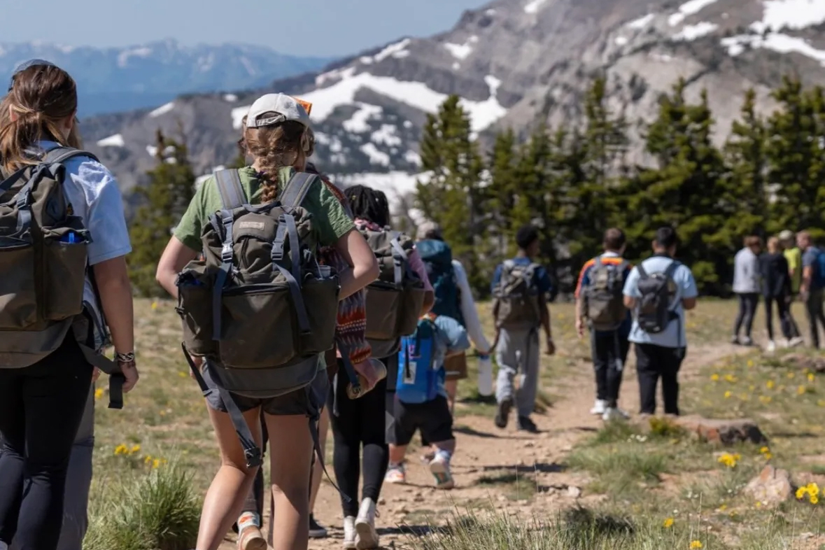 A group hikes towards a moutain