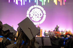 mortaboard in foreground and RISD seal in background at Commencement 2024